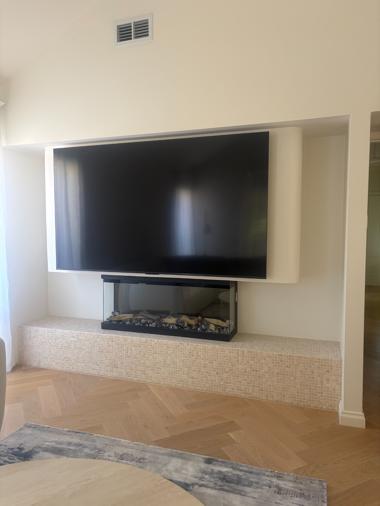 Curved fireplace feature with mosaic base